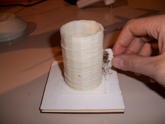Eine mit dem Makerbot erstellte Tasse. Sie ist weiß. Der Henkel ist defekt.